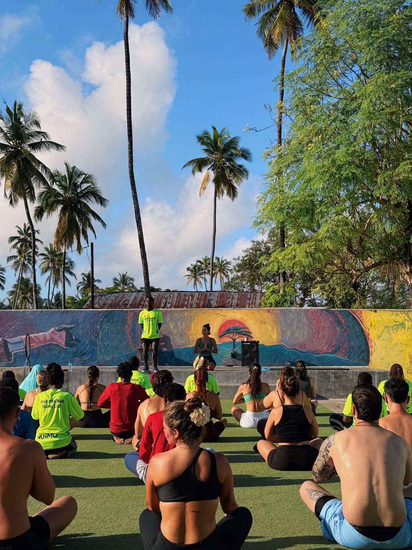 A group training session with visitors and local artists gathered at the painted mural wall