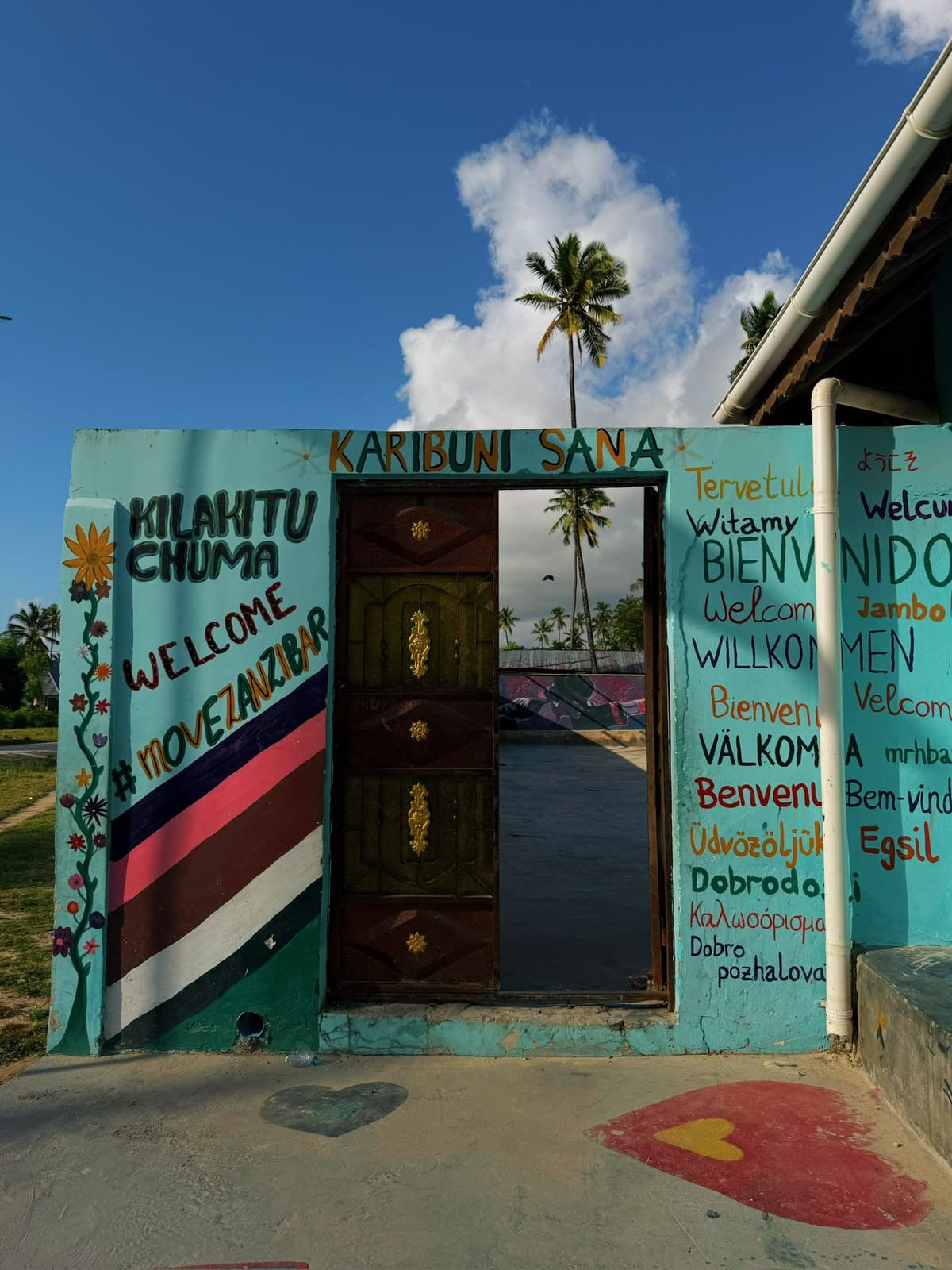 Entrance to the Move Zanzibar Community Centre in Jambiani, with its painted 'Karibuni Sana / Welcome' mural and a palm tree